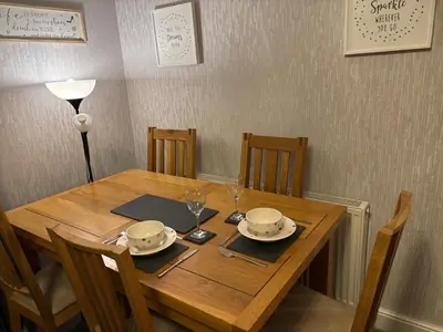 a wooden table with two plates and glasses on it at Stanley Suite in Liverpool