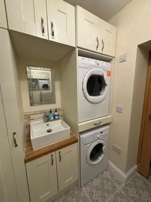 a small bathroom with a sink and a washing machine at Stanley Suite in Liverpool