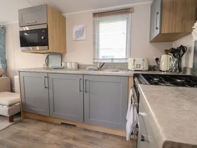 a kitchen with gray cabinets and a counter top at Poppy Lodge in Morecambe