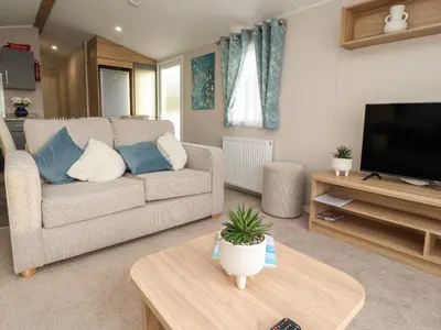 a living room with a couch and a tv at Poppy Lodge in Morecambe