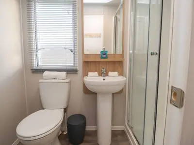 a bathroom with a toilet and a sink and a shower at Poppy Lodge in Morecambe