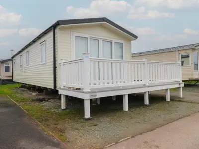 a large white house with a porch on a trailer at Poppy Lodge in Morecambe