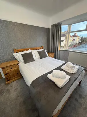 a bedroom with a large bed with two towels on it at Morton suite in Litherland