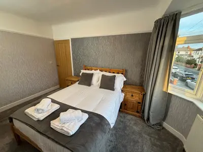 a bedroom with a bed with two towels on it at Morton suite in Litherland