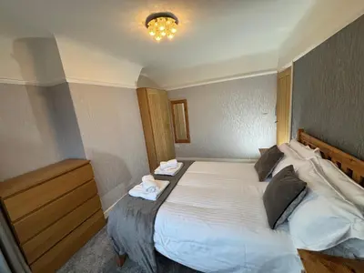 a bedroom with a large bed with towels on it at Morton suite in Litherland