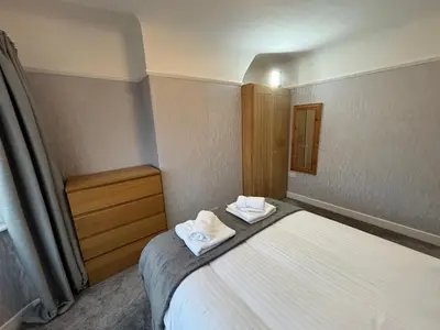 a small room with a bed with towels on it at Morton suite in Litherland