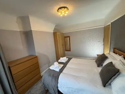 a bedroom with a bed with two towels on it at Morton suite in Litherland