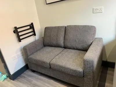 a couch in the corner of a room at The Stadium Hotel Anfield in Liverpool