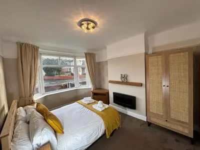 a bedroom with a large bed and a window at Henry suite in Litherland
