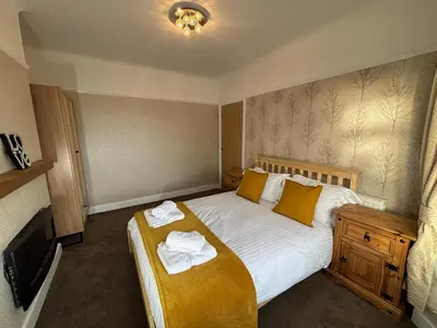a bedroom with a bed with towels on it at Henry suite in Litherland