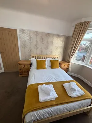 a bedroom with a large bed with towels on it at Henry suite in Litherland