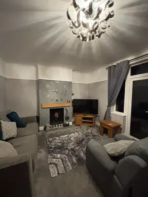 a living room with a couch and a fireplace at Thirlmere Stay in Litherland