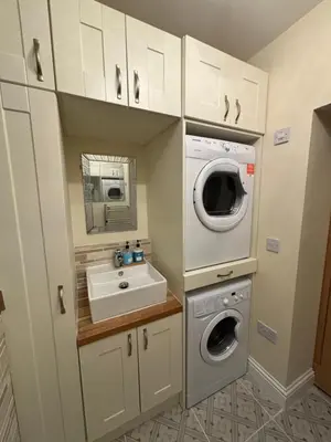 a small kitchen with a washing machine and a sink at Thirlmere Stay in Litherland