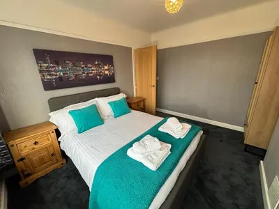 a bedroom with a bed with towels on it at Thirlmere Stay in Litherland