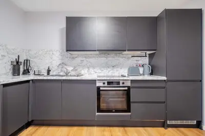 a kitchen with stainless steel appliances and gray cabinets at Host & Stay - Stanley Street Apartments in Liverpool