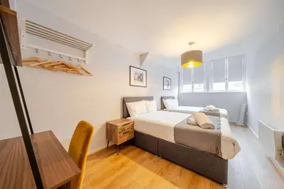 a bedroom with a large bed and a table at Host & Stay - Stanley Street Apartments in Liverpool