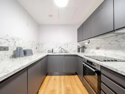 a kitchen with gray cabinets and white marble counter tops at Host & Stay - Stanley Street Apartments in Liverpool