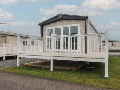 a mobile home with a white railing and a porch at The Retreat in Morecambe