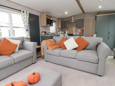 a living room with two couches and a kitchen at The Retreat in Morecambe