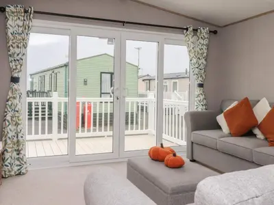 a living room with a couch and a sliding glass door at The Retreat in Morecambe