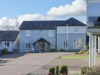 a large blue house with a driveway at Oversands View in Grange Over Sands