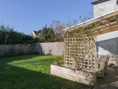 a garden with a plant in a planter next to a fence at Oversands View in Grange Over Sands