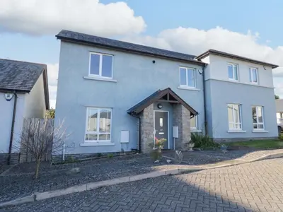a blue house with a brick driveway at Oversands View in Grange Over Sands