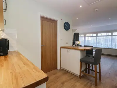 a kitchen with a desk and a chair in a room at Drapers Cottage in Grange Over Sands