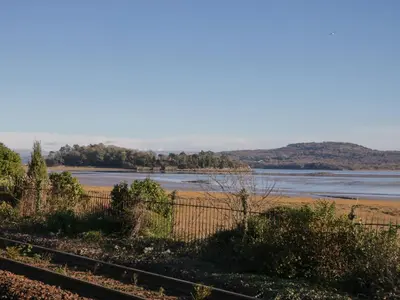 a view of a body of water with a fence at Drapers Cottage in Grange Over Sands