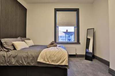 a bedroom with a bed and a mirror and a window at Chesterfield House, Blackpool, Free Parking in Blackpool