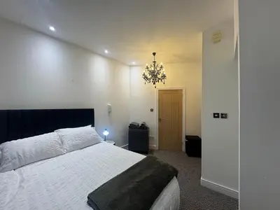 a bedroom with a large bed and a chandelier at Spacious 2 bed Apt Liverpool City Centre in Liverpool