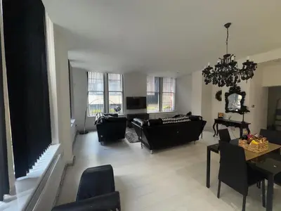 a living room with black furniture and a chandelier at Spacious 2 bed Apt Liverpool City Centre in Liverpool
