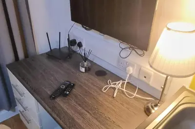 a desk with a lamp and a remote control on it at Central Liverpool 1-Bed Apartment City Centre in Liverpool