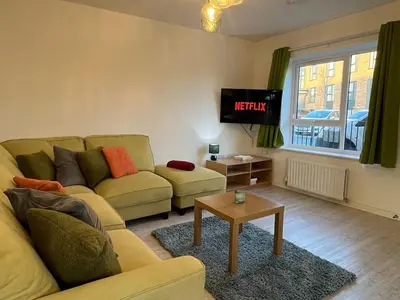 a living room with a couch and a tv at Two Bedroom House with Free Parking in Liverpool