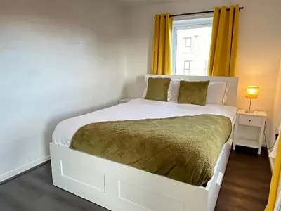 a white bed in a room with a window at Two Bedroom House with Free Parking in Liverpool
