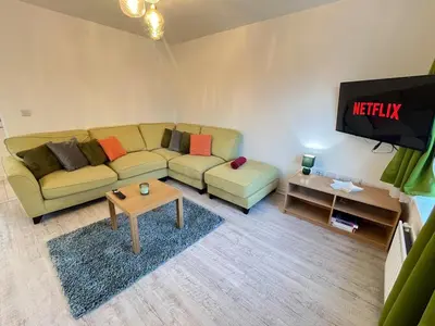 a living room with a couch and a tv at Two Bedroom House with Free Parking in Liverpool