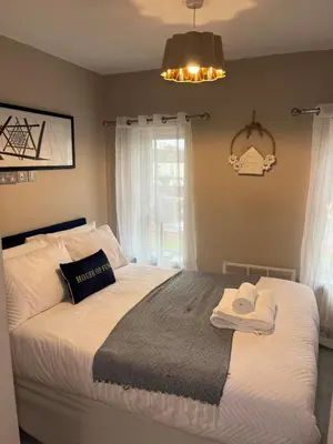 a bedroom with a bed with towels on it at 2BR Cosy Wallasey Stay Near Liverpool WiFi Parking in Wallasey