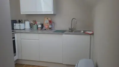 a kitchen with white cabinets and a sink at 2BR Cosy Wallasey Stay Near Liverpool WiFi Parking in Wallasey