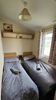 two beds in a small room with a window at Willerby Seasons in Morecambe