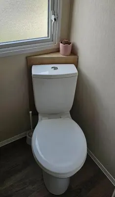 a white toilet in a bathroom with a window at Willerby Seasons in Morecambe