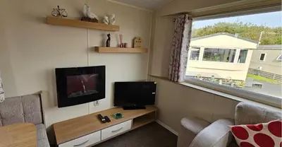 a living room with a tv and a couch and a window at Willerby Seasons in Morecambe