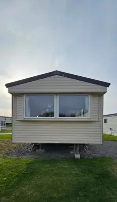 a small house with a large window in a yard at Willerby Seasons in Morecambe