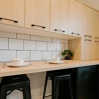a kitchen counter with two plates and wine glasses at Cosy New Brighton Room for Rent in New Brighton