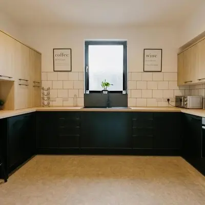 a kitchen with black cabinets and a window at Cosy New Brighton Room for Rent in New Brighton