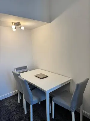 a white table with two chairs and a book on it at Holgate Cottage in Great Harwood