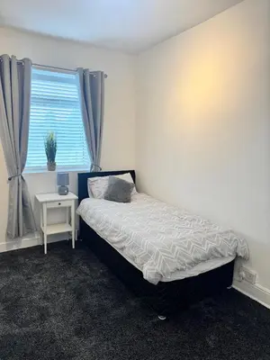 a small bedroom with a bed and a window at Holgate Cottage in Great Harwood