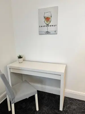 a white desk with a chair and a picture on the wall at Holgate Cottage in Great Harwood