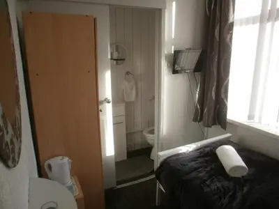 a small bathroom with a bed and a toilet at Marsden B&B in Blackpool