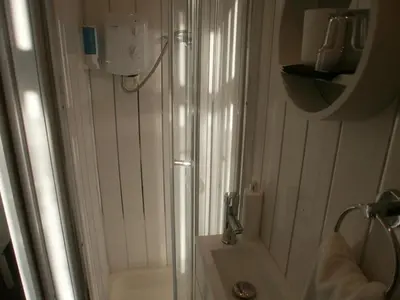 a white bathroom with a shower and a sink at Marsden B&B in Blackpool