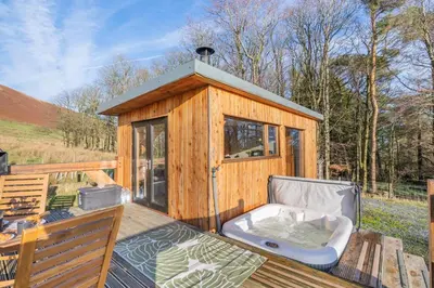 a wooden cabin with a bath tub on a deck at 1 Bed in Newton In Bowland oc-h34064 in Newton